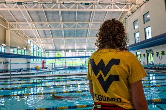 A Campus Rec lifeguard looks on as patrons swim in the lap pool. 