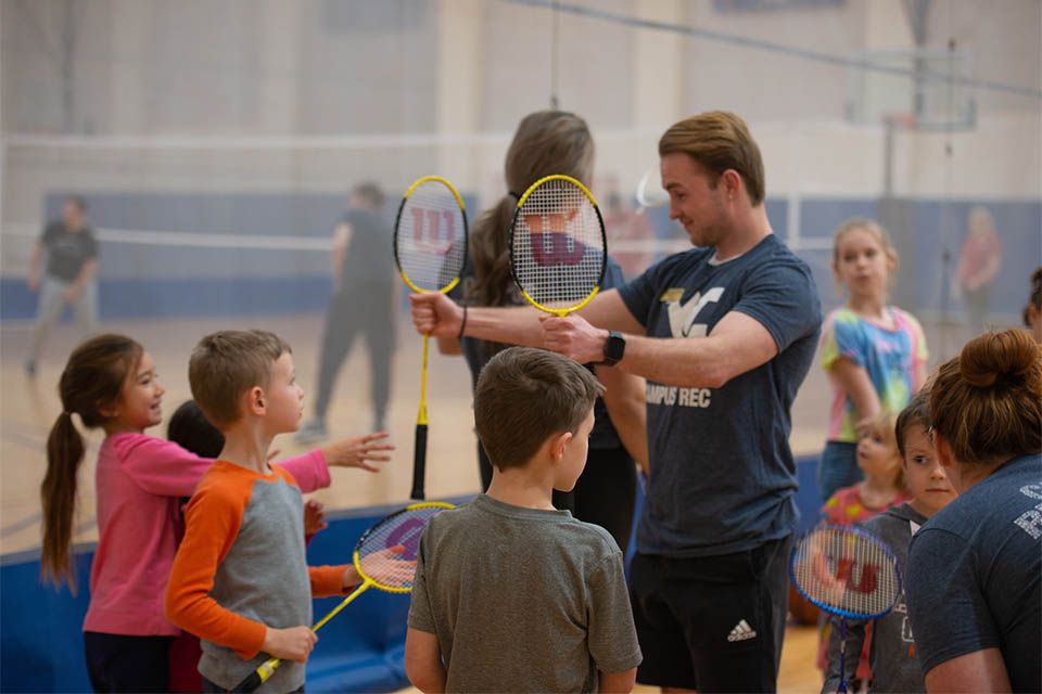 Counselor holding rackets for kids